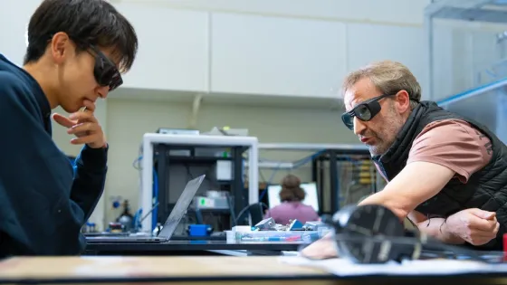 Researchers wearing protective glasses working in a lab