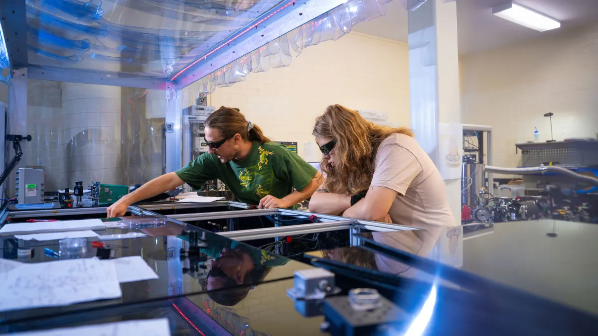 Researchers photographed in the ANU Centre for Gravitational Astrophysics (CGA) Lab